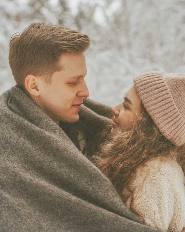 Couple sitting close together and looking into each other’s eyes during a couples therapy session.